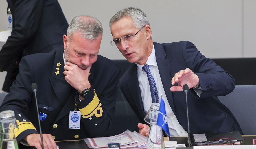 NATO Secretary-General Jens Stoltenberg, right, talks to Chair of the NATO Military Committee, Admiral Rob Bauer during a meeting of NATO defense ministers in the Ukraine Defense Contact Group format at NATO headquarters in Brussels, Wednesday, Oct. 12, 2022. (AP Photo/Olivier Matthys)