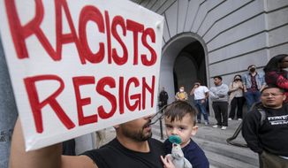 Shervin Aazami holding his son Barrett and a sign protest outside City Hall during the Los Angeles City Council meeting Tuesday, Oct. 11, 2022 in Los Angeles. (AP Photo/Ringo H.W. Chiu)