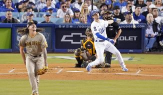 Los Angeles Dodgers&#39; Trea Turner, right, hits a solo home run as San Diego Padres starting pitcher Mike Clevinger, left, and catcher Austin Nola watch during the first inning in Game 1 of a baseball NL Division Series Tuesday, Oct. 11, 2022, in Los Angeles. (AP Photo/Marcio Jose Sanchez)