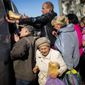 Locals receive food and everyday necessities given by Ukrainian volunteers in Izium, Ukraine, Wednesday, Oct. 12, 2022. Residents in Izium have been living with no gas, electricity or running water supply since the beginning of September. (AP Photo/Francisco Seco)