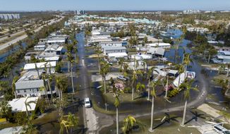 Water floods a damaged trailer park in Fort Myers, Fla., on Oct. 1, 2022, after Hurricane Ian passed by the area. Florida Gov. Ron DeSantis on Thursday, Oct. 13, 2022 announced an executive order expanding voting access for the midterm elections in three counties where Hurricane Ian destroyed polling places and displaced thousands of people. (AP Photo/Steve Helber, File)