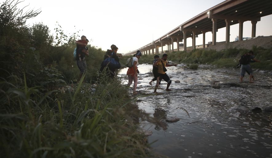 Venezuelan migrants walk across the Rio Bravo towards the United States border to surrender to the border patrol, from Ciudad Juarez, Mexico, Thursday, Oct. 13, 2022. The U.S. announced on Oct. 12, that Venezuelans who walk or swim across the border will be immediately returned to Mexico without rights to seek asylum. (AP Photo/Christian Chavez)