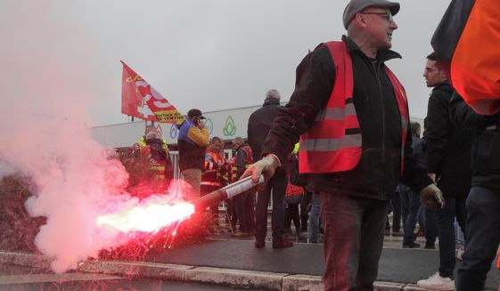 Striking workers gather at the entrance of the TotalEnergies oil depot, Thursday, Oct.13, 2022 outside Dunkirk, northern France. French President Emmanuel Macron promised the situation in the country&#39;s gas stations will soon be back to &amp;quot;normal&amp;quot; as the government started requisitioning some workers at ExxonMobil&#39;s Esso gas stations amid an ongoing strike that is making life difficult for French drivers. The government is considering making a similar decision soon regarding Total facilities, depending on the outcome of salary negotiations . (AP Photo/Michel Spingler)