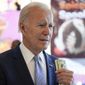 President Joe Biden stands with his money as he waits for his ice cream cone at a Baskin-Robbins in Portland, Ore., Saturday, Oct. 15, 2022. (AP Photo/Carolyn Kaster)