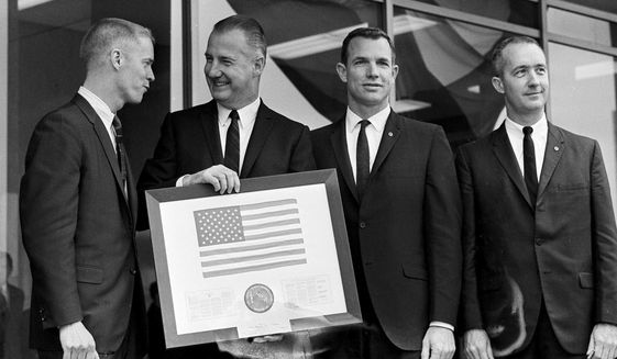 Vice President Spiro Agnew holds a framed American flag, presented to him by the crew of Apollo 9, as he poses with the astronauts March 26, 1969, in Washington. From left: Russell Schweikart, Agnew, and Air Force Cols. David Scott and James McDivitt. McDivitt, who commanded the Apollo 9 mission testing the first complete set of equipment to go to the moon, died Thursday, Oct. 13, 2022. He was 93. (AP Photo/Harvey Georges, File)
