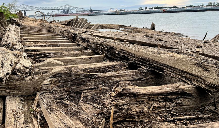 The remains of a ship lay on the banks of the Mississippi River in Baton Rouge, La., on Monday, Oct. 17, 2022, after recently being revealed due to the low water level. The ship, which archaeologists believe to be a ferry that sunk in the late 1800s to early 1900s, was spotted by a Baton Rouge resident walking along the shore earlier this month. (AP Photo/Sara Cline)
