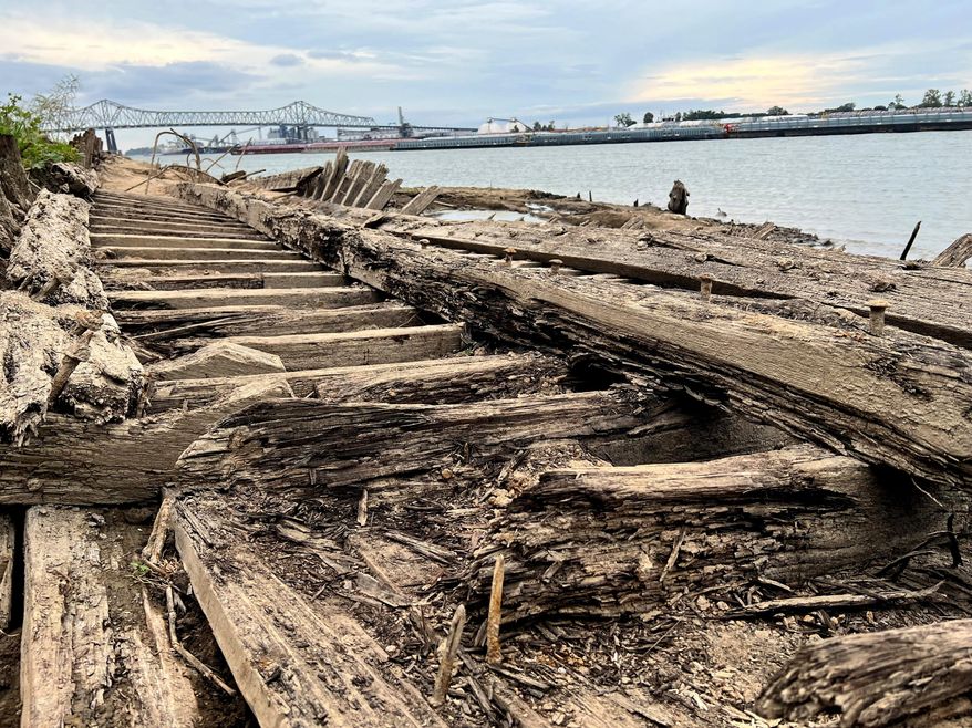 The remains of a ship lay on the banks of the Mississippi River in Baton Rouge, La., on Monday, Oct. 17, 2022, after recently being revealed due to the low water level. The ship, which archaeologists believe to be a ferry that sunk in the late 1800s to early 1900s, was spotted by a Baton Rouge resident walking along the shore earlier this month. (AP Photo/Sara Cline)
