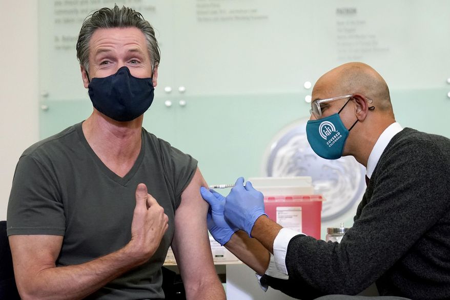 California Gov. Gavin Newsom, left, receives a Moderna COVID-19 vaccine booster shot from California Health and Human Services Secretary Dr. Mark Ghaly at Asian Health Services in Oakland, Calif., on Oct. 27, 2021. On Monday, Oct. 17, 2022, Newsom announced he will lift the coronavirus state of emergency at the end of February 2023. The announcement will officially end all of the pandemic-related executive orders Newsom has issued since 2020. (AP Photo/Jeff Chiu, File)