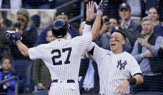 New York Yankees Giancarlo Stanton (27) celebrates with Aaron Judge after hitting a three-run home run against the Cleveland Guardians during the first inning of Game 5 of an American League Division baseball series, Tuesday, Oct. 18, 2022, in New York. (AP Photo/John Minchillo)