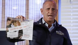 Don Bolduc, a  Republican candidate for U.S. Senate in New Hampshire, holds up a mailing from the opposition as he campaigns at the Auburn Tavern, Wednesday, Oct. 5, 2022, in Auburn, N.H. (AP Photo/Mary Schwalm)