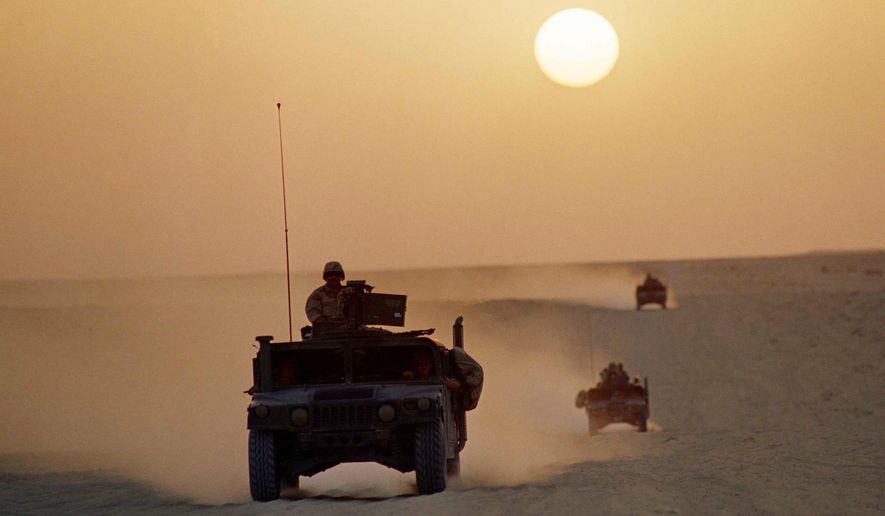 A group of Marine Humvees, deployed in forward positions as part of Operation Desert Shield, tear across the Saudi desert under a setting sun on Oct. 2, 1990 in Saudi Arabia. Former award-winning Associated Press photographer John Gaps III, who documented everything from war zones to the NCAA College World Series during his career, was found dead at his home Monday, Oct. 17, 2022, in Des Moines, Iowa, his family confirmed Tuesday. He was 63. (AP Photo/John Gaps III, File)
