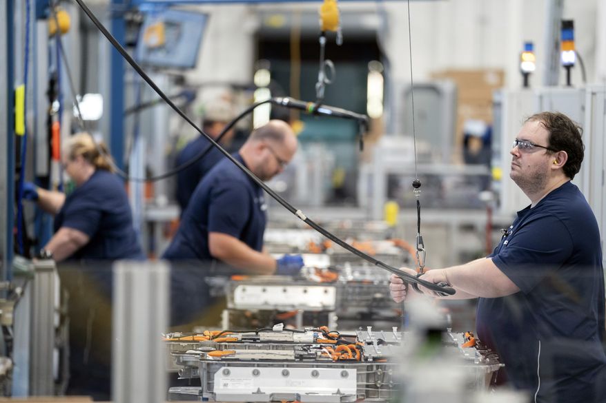 Employees work in the battery assembly hall at the BMW Spartanburg plant in Greer, S.C., Wednesday, Oct. 19, 2022. BMW's sprawling factory near Spartanburg, will get a $1 billion investment, and the German automaker will spend another $700 million to build a battery plant nearby as it begins the transition to electric vehicles in the U.S., the company announced. (AP Photo/Sean Rayford)