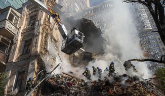 Firefighters work after a drone attack on buildings in Kyiv, Ukraine, on  Oct. 17, 2022. The Iranian-made drones that Russia sent slamming into central Kyiv this week have produced hand-wringing and consternation in Israel, complicating the country’s balancing act between Russia and the West. (AP Photo/Roman Hrytsyna)