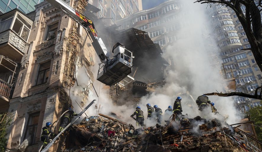 Firefighters work after a drone attack on buildings in Kyiv, Ukraine, Oct. 17, 2022. As protests rage at home, Iran&#x27;s theocratic government is increasingly flexing its military muscle abroad. That includes supplying drones to Russia that now kill Ukrainian civilians, running drills in a border region with Azerbaijan and bombing Kurdish positions in Iraq. (AP Photo/Roman Hrytsyna, File)