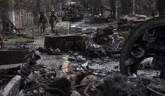 Soldiers walk amid destroyed Russian tanks in Bucha, in the outskirts of Kyiv, Ukraine, April 3, 2022. Eight months after Russian President Vladimir Putin launched an invasion against Ukraine expecting a lightning victory, the war continues, affecting not just Ukraine but also exacerbating death and tension in Russia among its own citizens. (AP Photo/Rodrigo Abd, File)