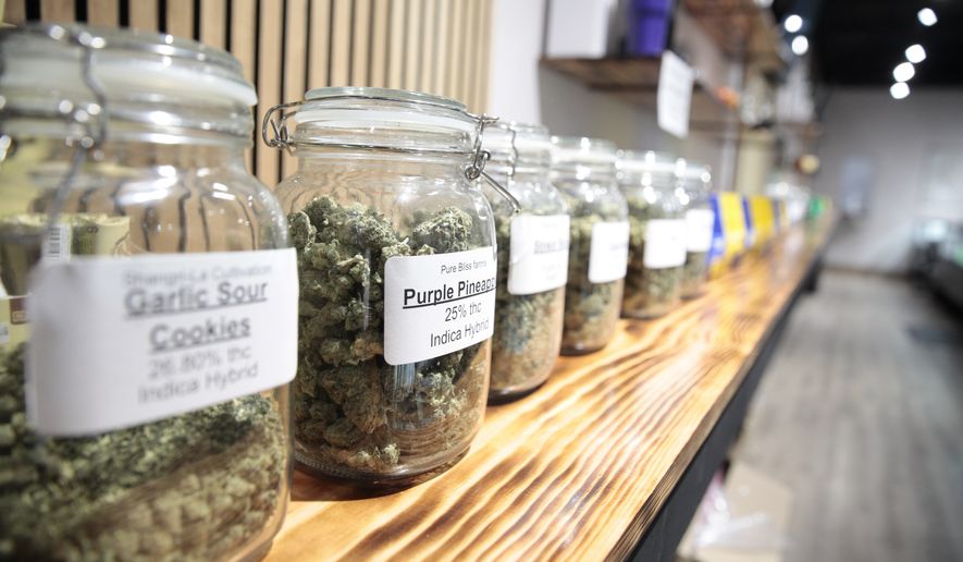 Jars of marijuana line a shelf at The Flower Shop Dispensary in Sioux Falls, S.D. on Oct. 14, 2022. South Dakota&#x27;s legal pot industry has started with medical cannabis, but voters are deciding whether to also legalize recreational pot. (AP Photo/Stephen Groves)