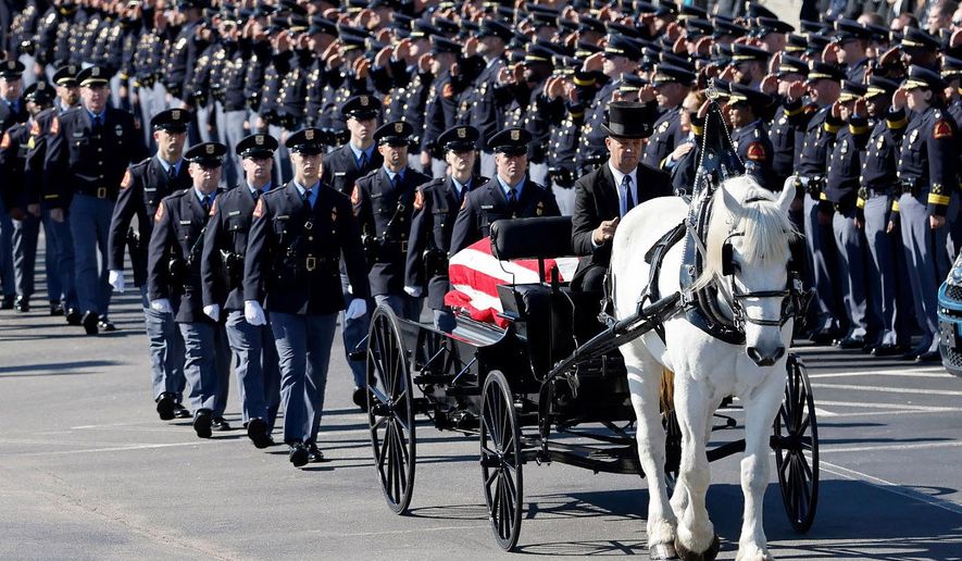 A funeral caisson transports the casket of Raleigh Police Officer Gabriel Torres to Cross Assembly Church in Raleigh, N.C. for his funeral Saturday, Oct. 22, 2022. Torres, a Raleigh police officer and former U.S. Marine, was inside his personal vehicle and about to leave for work when authorities said he was shot by a 15-year-old boy wearing camouflage clothing and firing a shotgun.  (Ethan Hyman/The News &amp;amp; Observer via AP)