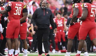 Maryland head coach Michael Locksley talks with his team during a timeout against Northwestern in the first half of an NCAA college football game, Saturday, Oct. 22, 2022, in College Park, Md. (AP Photo/Gail Burton)