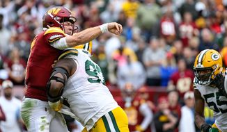Washington Commanders quarterback Taylor Heinicke (4) closes his eyes and braces for impact on a fourth-quarter completion to receiver Terry McLaurin (17) against the Green Bay Packers at FedEx Field, Landover, MD, October 23, 2022. (Photo by Brian Murphy)