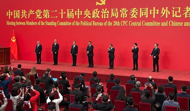 New members of the Politburo Standing Committee, from left, Li Xi, Cai Qi, Zhao Leji, President Xi Jinping, Li Qiang, Wang Huning, and Ding Xuexiang are introduced at the Great Hall of the People in Beijing, Sunday, Oct. 23, 2022. (AP Photo/Andy Wong)