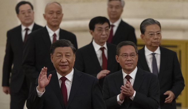 New members of the Politburo Standing Committee, front to back, President Xi Jinping, Li Qiang, Zhao Leji, Wang Huning, Cai Qi, Ding Xuexiang, and Li Xi arrive at the Great Hall of the People in Beijing on Oct. 23, 2022. The world faces the prospect of more tension with China over trade, security and human rights after Xi Jinping awarded himself a third five-year term on Oct. 23, 2022, as leader of the ruling Communist Party. (AP Photo/Ng Han Guan, File)