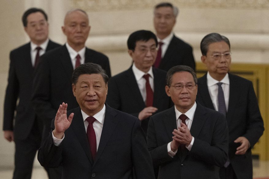 New members of the Politburo Standing Committee, front to back, President Xi Jinping, Li Qiang, Zhao Leji, Wang Huning, Cai Qi, Ding Xuexiang, and Li Xi arrive at the Great Hall of the People in Beijing on Oct. 23, 2022. The world faces the prospect of more tension with China over trade, security and human rights after Xi Jinping awarded himself a third five-year term on Oct. 23, 2022, as leader of the ruling Communist Party. (AP Photo/Ng Han Guan, File)
