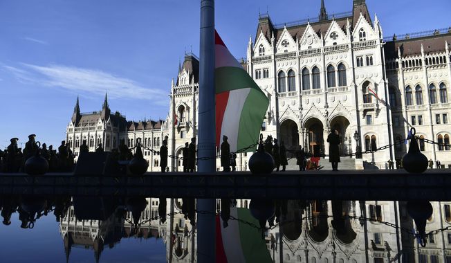 The official flag raising ceremony for the 66th anniversary of Hungarian anti-communist uprising of 1956 in front of the Parliament in Budapest, Hungary, Sunday, Oct. 23, 2022. (AP Photo/Anna Szilagyi)