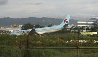 A damaged Korean Air plane lies after it overshot the runway at the Mactan-Cebu International Airport in Cebu, central Philippines, on early Monday, Oct. 24, 2022. The Korean Air plane overshot the runway while landing in bad weather in the central Philippines late Sunday, but authorities said all 173 people on board were safe. (AP Photo/Juan Carlo De Vela)