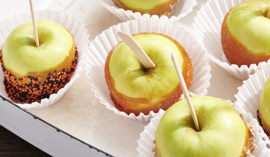 Caramel apples are displayed in New York in October 2020. Homemade caramel apples are surprisingly easy to make. You can use whatever apples you like, as long as they are firm and crisp (Cheyenne M. Cohen via AP)