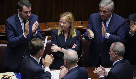 Italian Premier Giorgia Meloni, center, receives the applause after addressing the lower Chamber ahead of a confidence vote for her Cabinet, Tuesday, Oct. 25, 2022. Giorgia Meloni, whose party with neo-fascist roots finished first in recent elections, is Italy&#x27;s first far-right premier since the end of World War II. She is also the first woman to serve as Italian premier. At right Foreign Minister Antonio Tajani and at left, Infrastructures Minister Matteo Salvini. (AP Photo/Alessandra Tarantino)