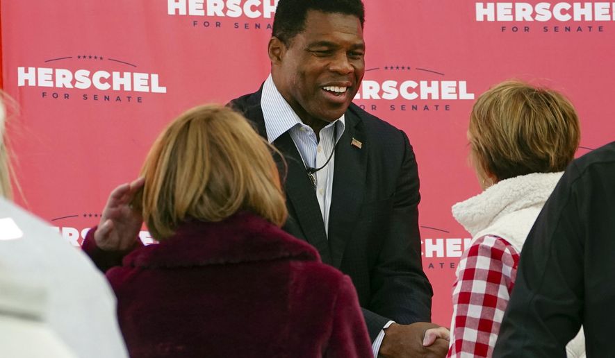 Herschel Walker, Republican candidate for U.S. Senate in Georgia, greets supporters during a campaign rally Oct. 18, 2022, in Atlanta. Walker campaigns for the U.S. Senate as a champion of free enterprise and advocate for the mentally ill, felons and others. And the Georgia Republican has called for policies that blend those priorities. Yet Walker, through a major chicken processor that he touts as a principal partner to one of his primary businesses,  has benefited from years of unpaid labor by drug offenders routed to the facility by Oklahoma state courts. (AP Photo/John Bazemore, File)
