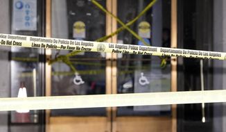 Police tape put up by protesters blocks the entrance of Los Angeles City Hall, Wednesday, Oct. 19, 2022, in Los Angeles. The demonstrators demanded the city council stop its virtual meeting Tuesday until two of its members resign over racist remarks. (AP Photo/Mark J. Terrill)