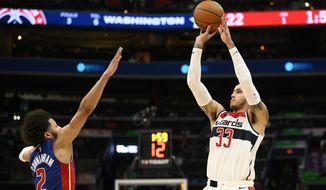 Washington Wizards forward Kyle Kuzma (33) shoots Detroit Pistons guard Cade Cunningham (2) during the first half of an NBA basketball game, Tuesday, Oct. 25, 2022, in Washington. (AP Photo/Nick Wass)