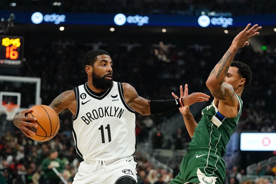Brooklyn Nets&#x27; Kyrie Irving tries to get past Milwaukee Bucks&#x27; George Hill during the first half of an NBA basketball game Wednesday, Oct. 26, 2022, in Milwaukee. (AP Photo/Morry Gash)
