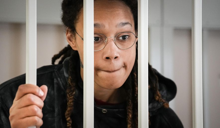 WNBA star and two-time Olympic gold medalist Brittney Griner speaks to her lawyers standing in a cage at a courtroom prior to a hearing, in Khimki just outside Moscow, Russia, Tuesday, July 26, 2022. (AP Photo/Alexander Zemlianichenko, Pool, File)