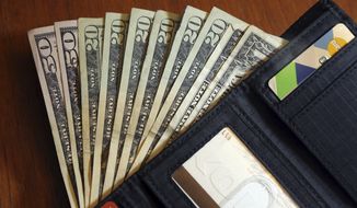 FILE - Cash is fanned out from a wallet in North Andover, Mass., June 15, 2018. The U.S. economy grew faster than expected in the July-September 2022 quarter, the government reported Thursday, Oct. 27, 2022, underscoring that the United States is not in a recession despite distressingly high inflation and interest rate hikes by the Federal Reserve. But the economy is hardly in the clear. (AP Photo/Elise Amendola, File)