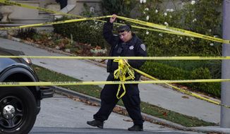 A police officer rolls out more yellow tape on the closed street below the home of Paul Pelosi, the husband of House Speaker Nancy Pelosi, in San Francisco, Friday, Oct. 28, 2022. Paul Pelosi, was attacked and severely beaten by an assailant with a hammer who broke into their San Francisco home early Friday, according to people familiar with the investigation. (AP Photo/Eric Risberg)