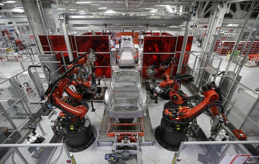 FILE - In this May 14, 2015 photo, Kuka robots work on Tesla Model S cars in the Tesla factory in Fremont, Calif. California revenues have been below expectations for four consecutive months. Democratic Gov. Gavin Newsom has said state officials should restrain spending. Last month, Newsom blocked a tax cut for manufacturers, citing the potential shortfall. (AP Photo/Jeff Chiu, File)