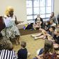 A drag performer by the name of Champagne Monroe reads the children&#39;s book &amp;quot;Rainbow Fish&amp;quot; to a group of kids and parents at the Mobile Public Library for Drag Queen Story Hour in Mobile, Ala. on Sept. 8, 2018. The art and entertainment form of drag has been miscast in recent months by right-wing activists and politicians who complain about the “sexualization” or “grooming” of children. The recent headlines about disruptions of drag events and their portrayal as sexual and harmful to children can obscure the intent of the art form and its rich history. (AP Photo/Dan Anderson, File)