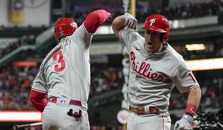 Philadelphia Phillies&#x27; J.T. Realmuto, right, celebrates his solo homer with Philadelphia Phillies Bryce Harper during the 10th inning in Game 1 of baseball&#x27;s World Series between the Houston Astros and the Philadelphia Phillies on Friday, Oct. 28, 2022, in Houston. (AP Photo/Eric Gay)