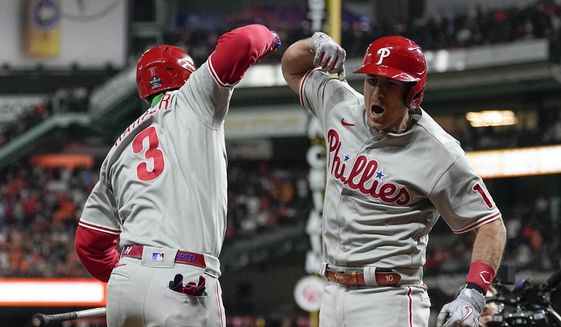 Philadelphia Phillies&#39; J.T. Realmuto, right, celebrates his solo homer with Philadelphia Phillies Bryce Harper during the 10th inning in Game 1 of baseball&#39;s World Series between the Houston Astros and the Philadelphia Phillies on Friday, Oct. 28, 2022, in Houston. (AP Photo/Eric Gay)