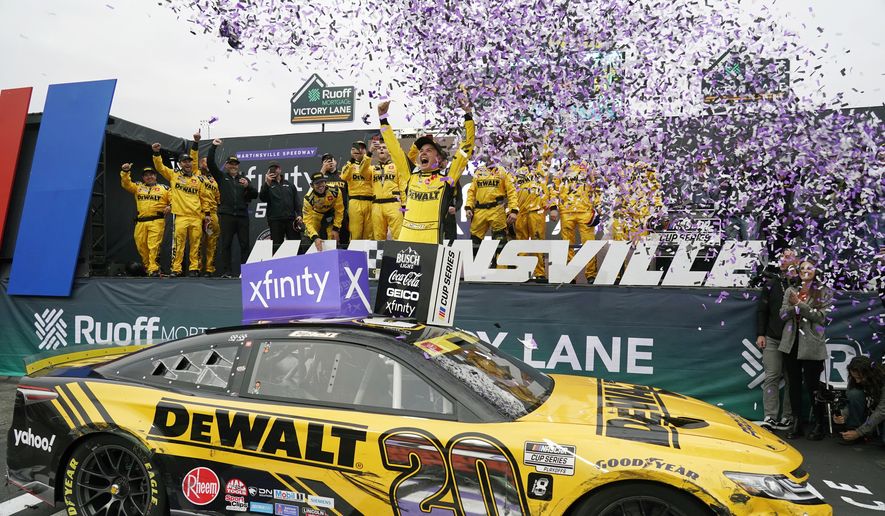Christopher Bell (20) celebrates in Victory Lane after winning a NASCAR Cup Series auto race at Martinsville Speedway, Sunday, Oct. 30, 2022, in Martinsville, Va. (AP Photo/Chuck Burton)