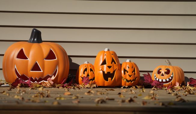 A display of Halloween pumpkins sits on the front porch of a home Thursday, Oct. 7, 2021, in Garretson, S.D. (AP Photo/David Zalubowski) ** FILE **