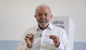 Former Brazilian President Luiz Inacio Lula da Silva, who is running for president again, poses for a picture after voting in a run-off presidential election in Sao Paulo, Brazil, Sunday, Oct. 30, 2022. (AP Photo/Andre Penner)