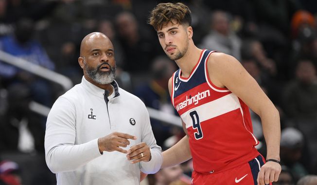 Washington Wizards head coach Wes Unseld Jr. talks with forward Deni Avdija (9) during the first half of an NBA basketball game against the Indiana Pacers, Friday, Oct. 28, 2022, in Washington. (AP Photo/Nick Wass)