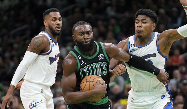 Boston Celtics guard Jaylen Brown, center, vies for control of the ball with Washington Wizards guard Monte Morris, left, and forward Rui Hachimura in the first half of an NBA basketball game, Sunday, Oct. 30, 2022, in Boston. (AP Photo/Steven Senne) **FILE**