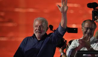 Former Brazilian President Luiz Inacio Lula waves to supporters gathered on Paulista Av. after he defeated incumbent Jair Bolsonaro in a presidential run-off election to become the country&#39;s next president, in Sao Paulo, Brazil, Sunday, Oct. 30, 2022. At right is running mate Geraldo Alckmin. (AP Photo/Andre Penner)