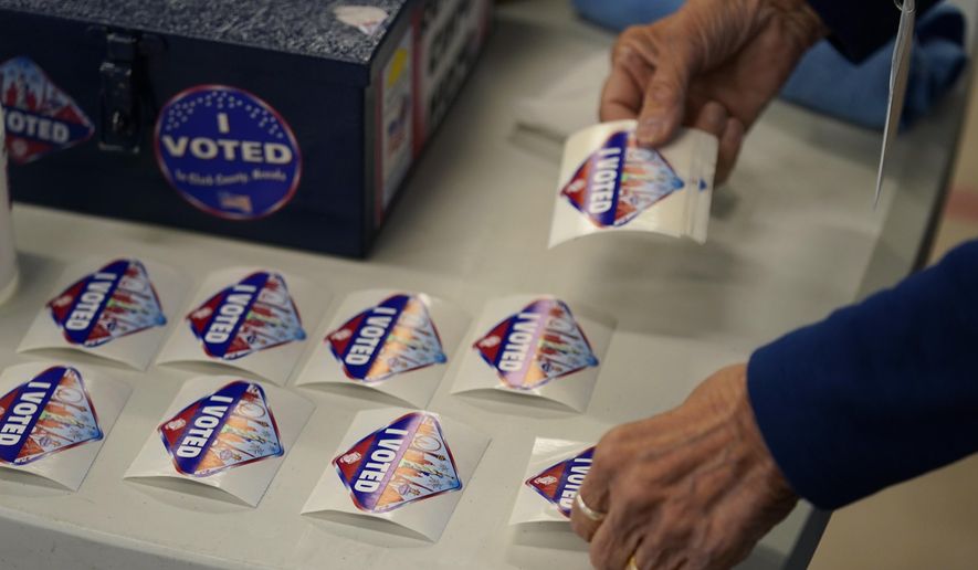 A poll worker lays out &quot;I Voted&quot; stickers at a polling place on June 14, 2022, in Las Vegas. (AP Photo/John Locher) **FILE**