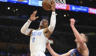 Los Angeles Lakers guard Russell Westbrook (0) goes to the basket against Denver Nuggets center Nikola Jokic (15) during the first half of an NBA basketball game Sunday, Oct. 30, 2022, in Los Angeles. (AP Photo/Michael Owen Baker)
