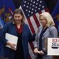 Reps. Elissa Slotkin, left, D-Mich., and Liz Cheney, R-Wyo., leave a campaign rally Tuesday, Nov. 1, 2022, in East Lansing, Mich., where Slotkin received the support of Cheney. Slotkin emphasized how a shared concern for a functioning democracy can unite Democrats and Republicans despite policy disagreements. (AP Photo/Carlos Osorio)